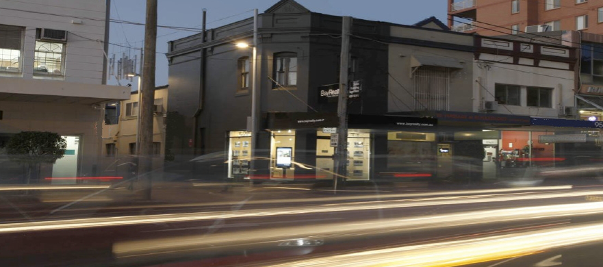 Bay Realty office on Princes Highway, Rockdale, at dusk with light trails from passing traffic