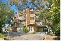 Apartment building with balconies surrounded by trees