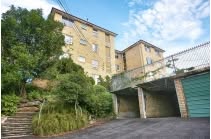 Apartment block on a leafy hillside with garages below