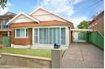 Red brick house with a front lawn and driveway