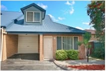 Brick townhouse with a garage and tiled roof